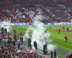 <h4>The Teams Emerge</h4>Notice the ManU end - they were given red and white cards to hold up but they mostly didn’t!