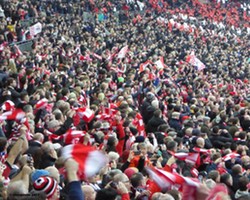 <h4>The Saints Fans</h4>on the Northern side join in – notice all the free scarves being waved – a good move by the club